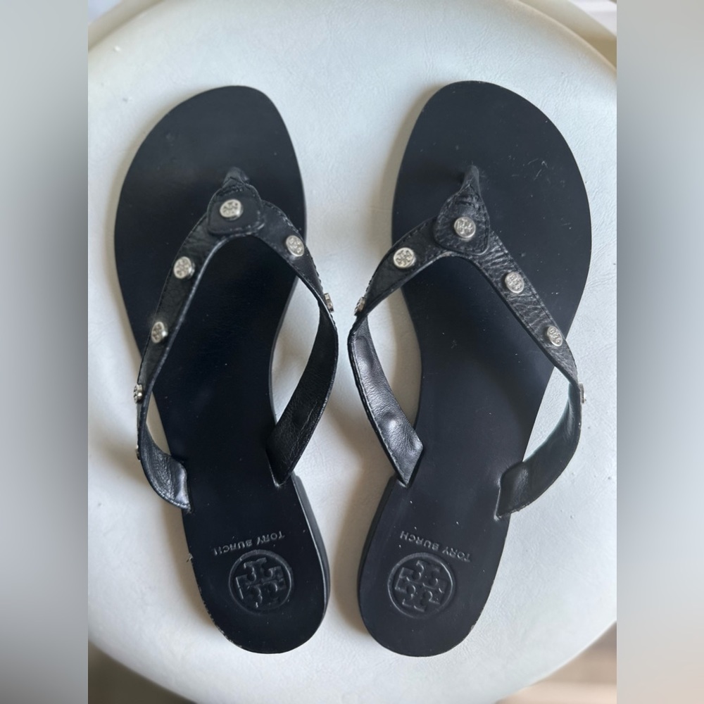 Tory Burch silver coin studded black leather flip flops.